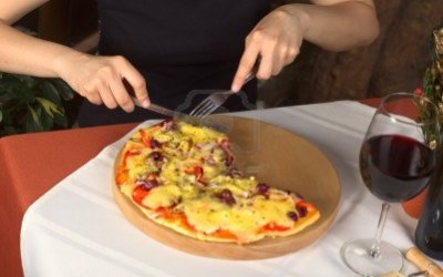 10547695-mujer-de-comer-pizza-vegetariana-en-una-pizzeria